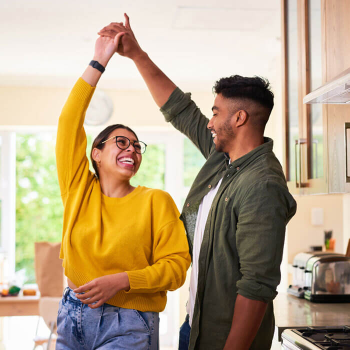 young couple dancing together in their kitchen